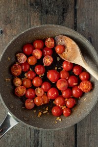 Tomaten und Knoblauch werden in einer Pfanne angebraten